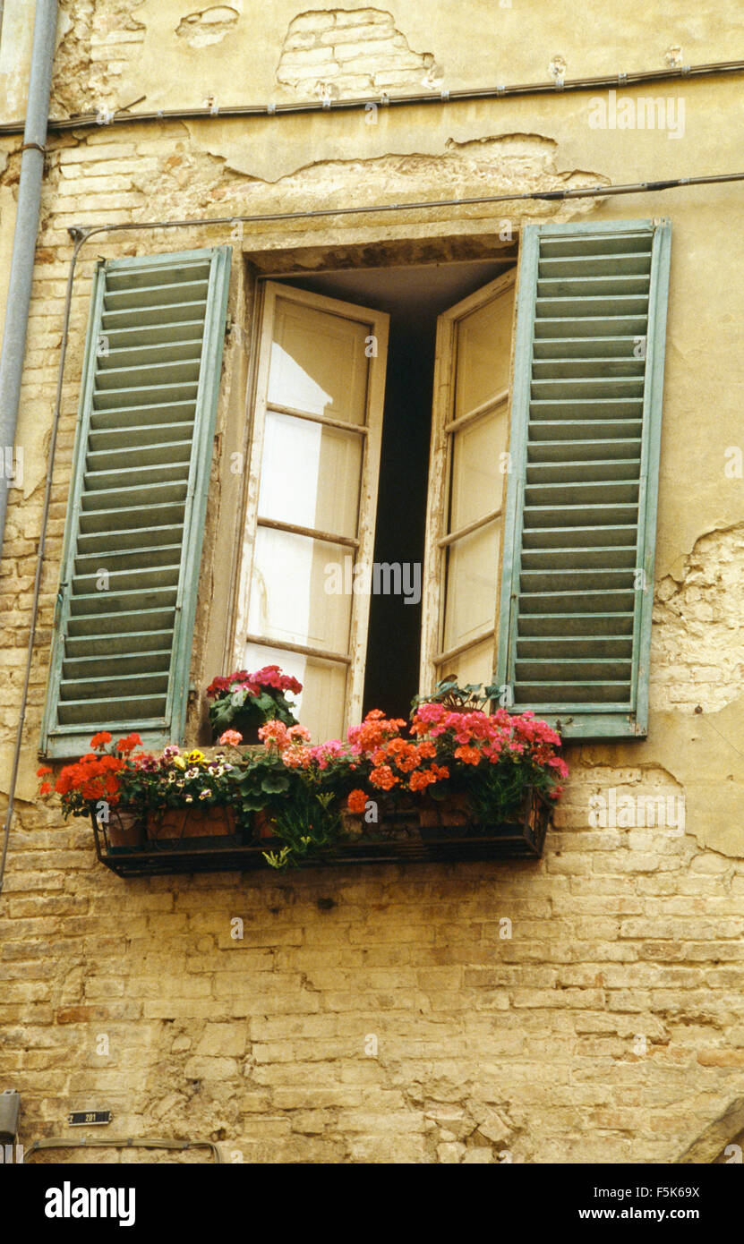 Eine französische Haus mit roten Geranien im Blumenkasten unter Fenster mit bemalten Fensterläden Stockfoto