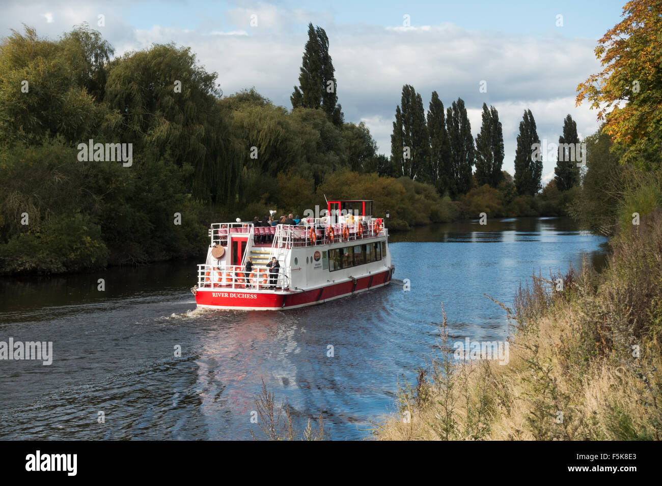 Passagiere auf Sightseeing-Bootsfahrt (Bootsfahrt auf dem malerischen Fluss Ouse, York, England, UK) sind gegen die Kälte an einem hellen, kühlen Herbsttag gewickelt. Stockfoto