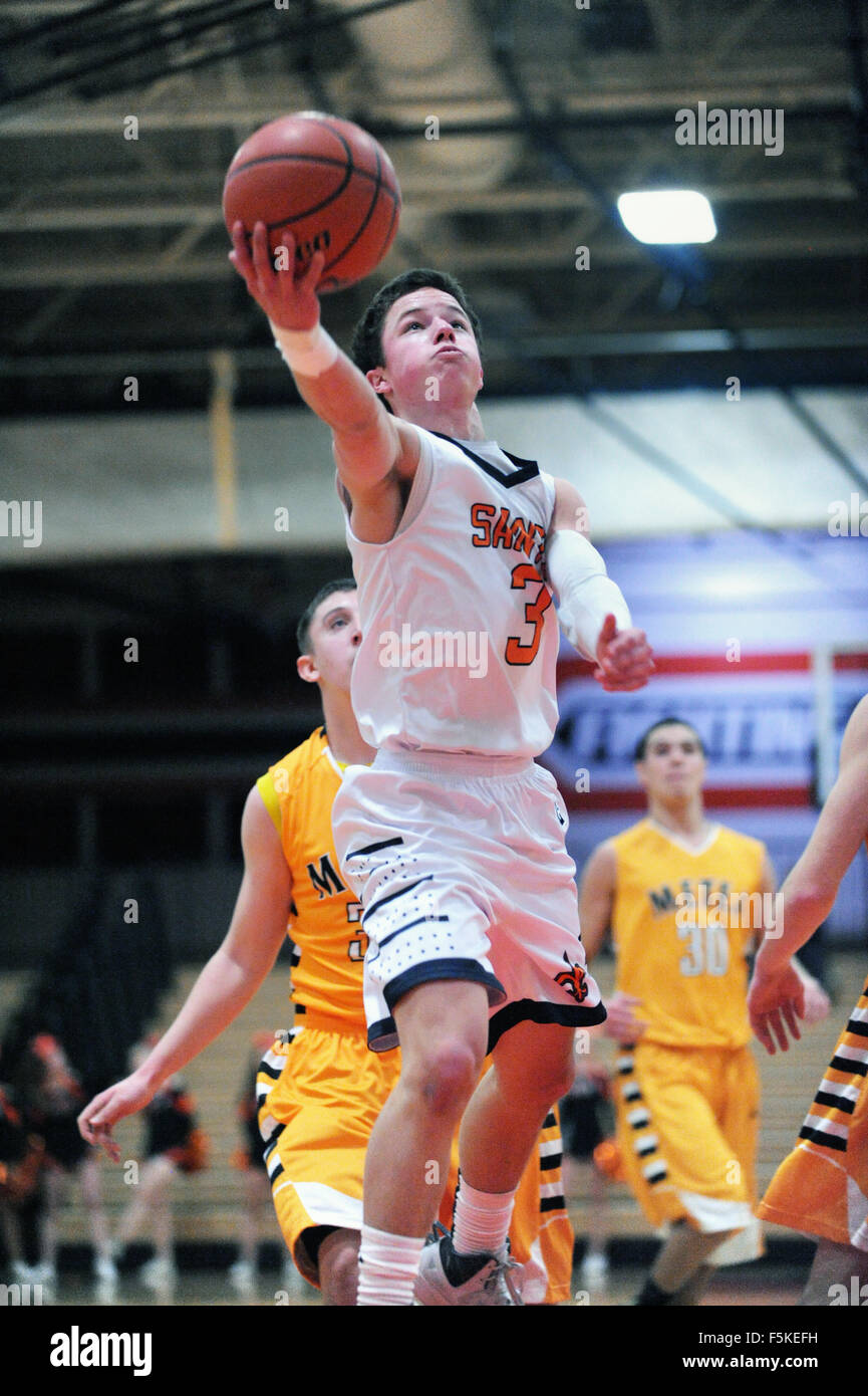 Spieler, der sich während eines Basketballspiels der High School vom Boden erhebt, um den Ball zum Reifen zu bringen. USA. Stockfoto