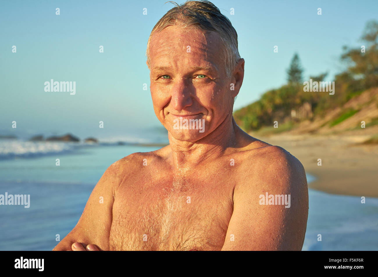 Reifen Alter Mann lächelnd nach dem Schwimmen im Ozean Stockfoto