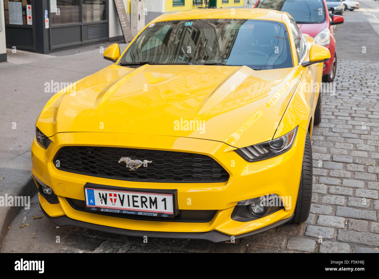 Wien, Österreich - 4. November 2015: Hell gelbes Ford Mustang 2015-Auto steht auf der Stadtstraße, Blick nach vorne zu schließen Stockfoto