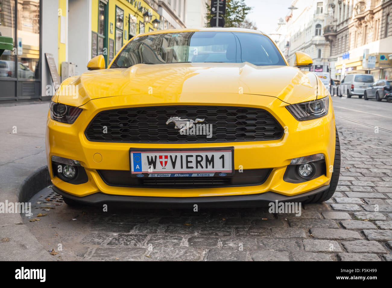 Wien, Österreich - 4. November 2015: Helles Gelb Ford Mustang 2015 Auto steht die Stadt Straße, Closeup-Vorderansicht Stockfoto
