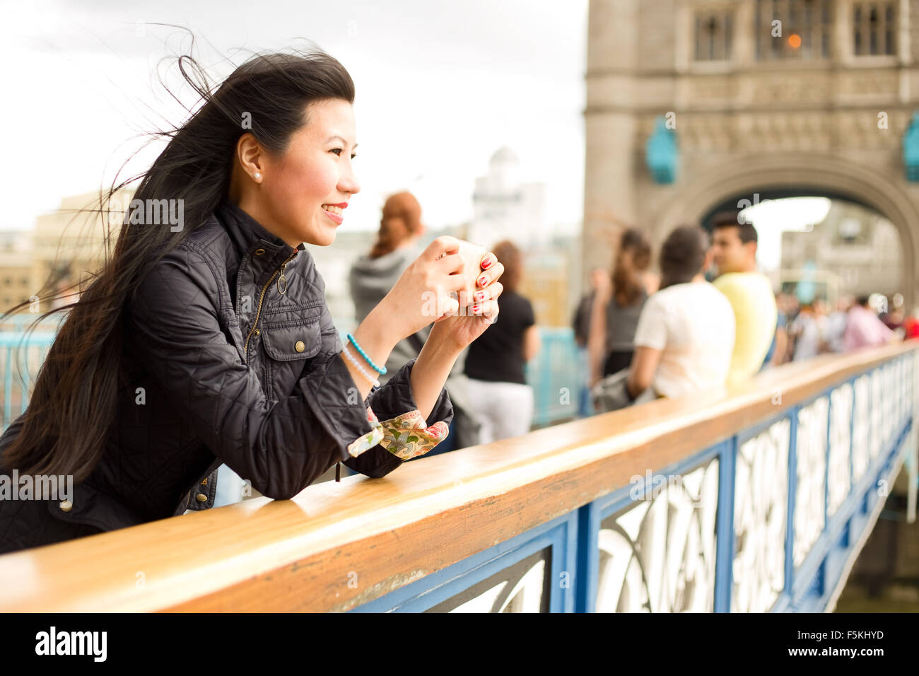 japanische Frau, die ein Foto mit ihrem Handy von der Tower bridge Stockfoto