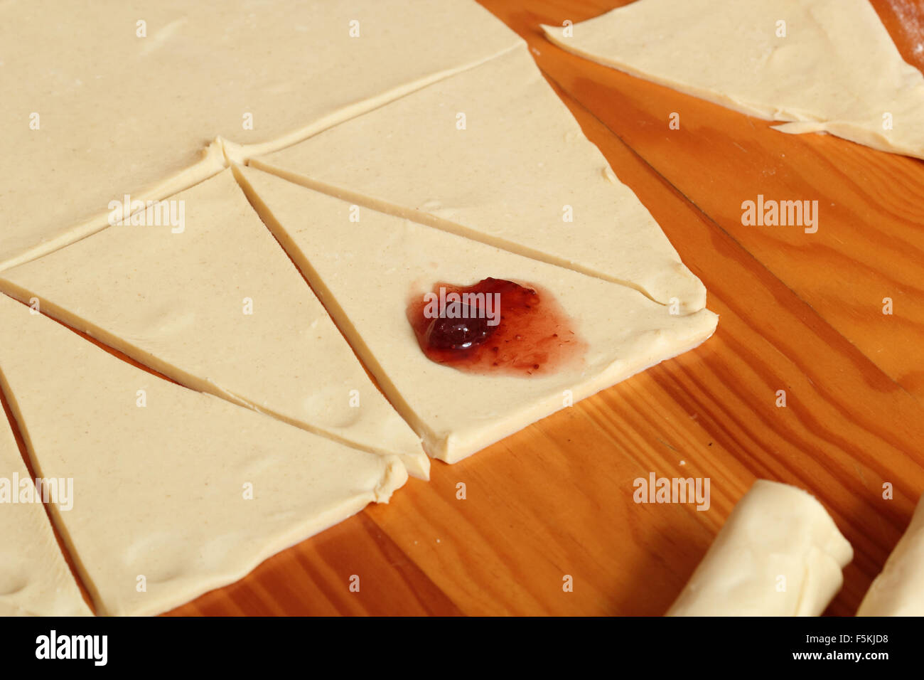 Croissants machen mit Erdbeer-Marmelade Stockfoto