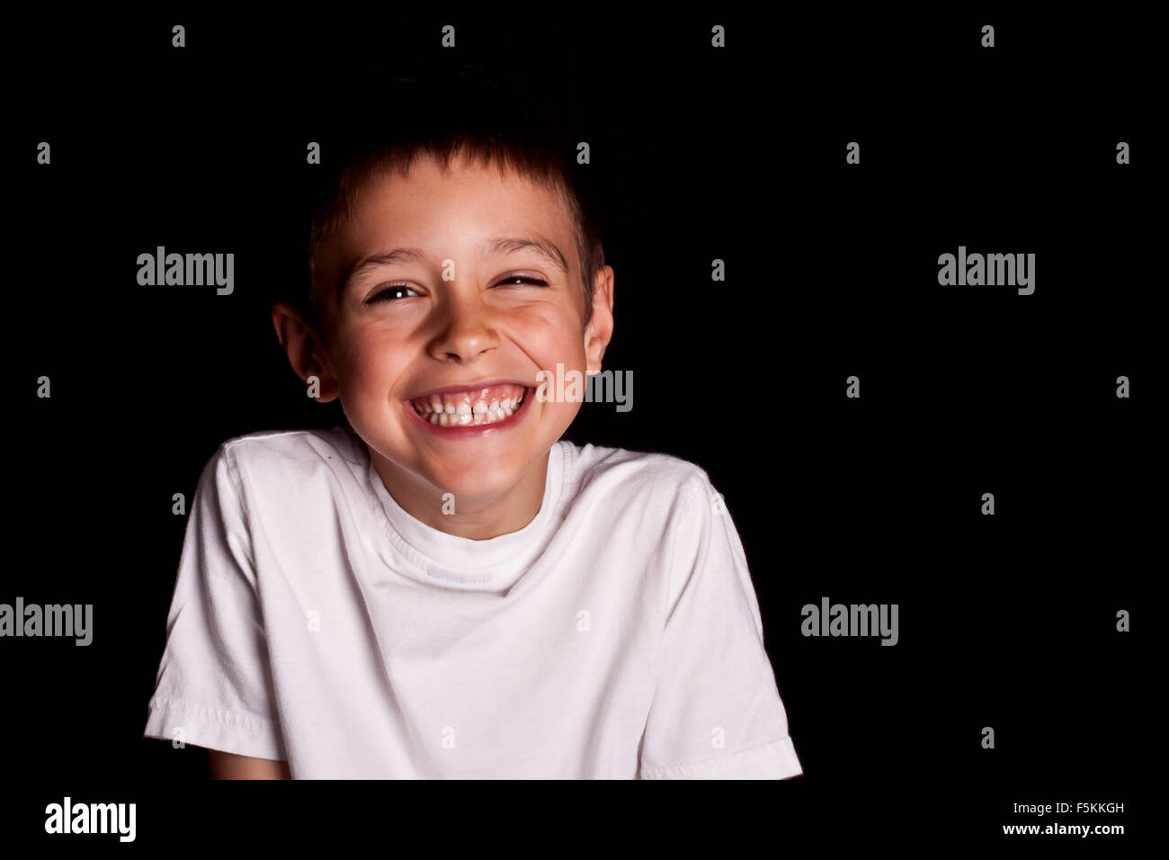 Lächelnde Kinder-t-Shirts in Weiß auf schwarzem Hintergrund. Modelle Stockfoto