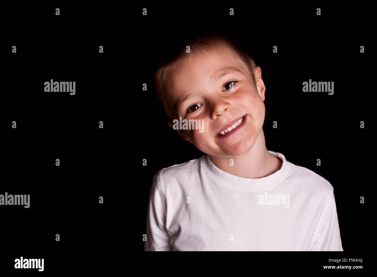 Lächelnde Kinder-t-Shirts in Weiß auf schwarzem Hintergrund. Modelle Stockfoto