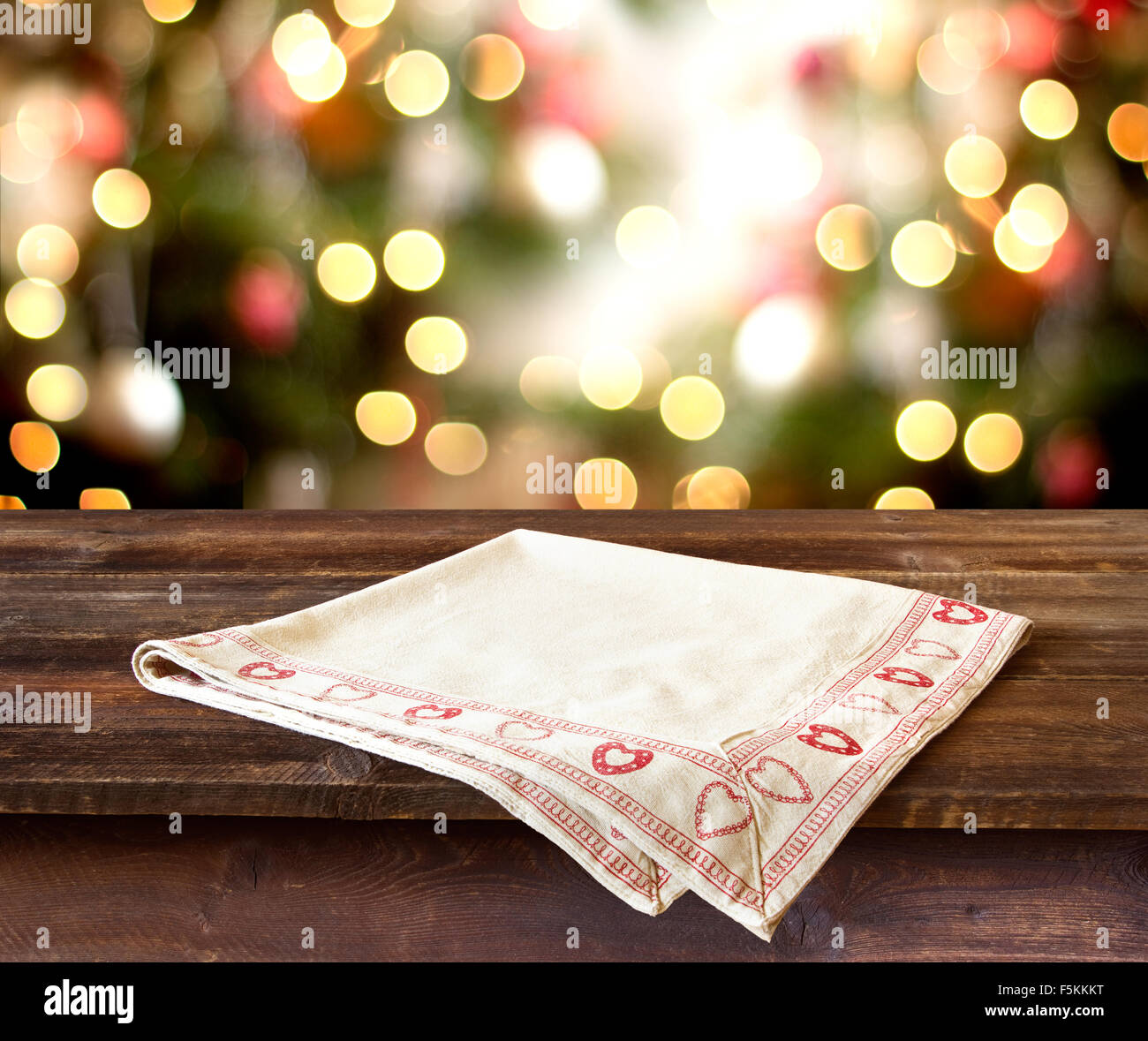 Weihnachten Hintergrund mit rustikalen Tisch mit Tischdecke gegen defokussierten Weihnachtsbeleuchtung Stockfoto