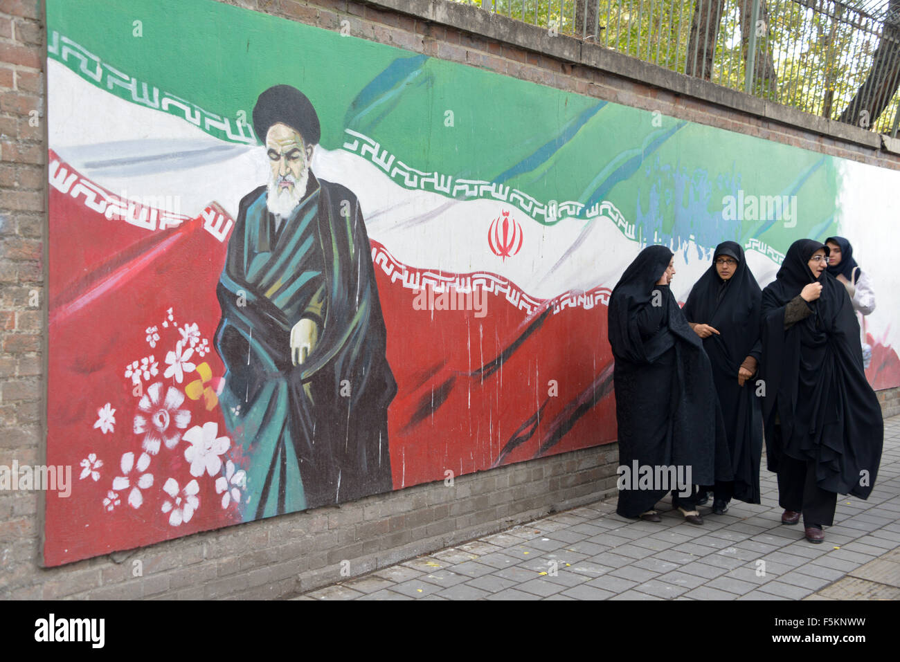 Teheran, Iran. 4. November, 2015.veiled Iraner Frauen geht Vergangenheit ein Ajatollah Khomeini Bild gemalt an der Wand des ehemaligen US-Botschaft in Teheran, Iran. Tausende Iraner die amerikanische Flagge verbrannt und skandierten Parolen Mittwoch, wie sie den Jahrestag der Beschlagnahmung der US-Botschaft in Teheran von Studenten vor 36 Jahren markiert Stockfoto