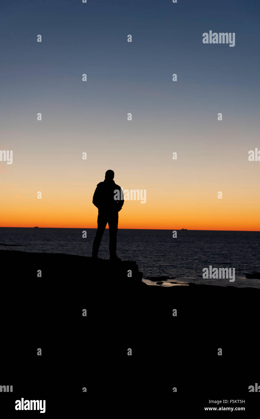 Schweden, Bohuslan, Silhouette der Mann am Strand in der Abenddämmerung Stockfoto