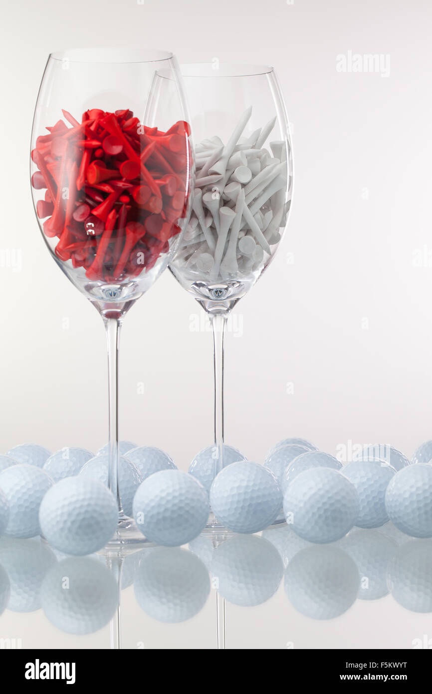 Zwei Gläser Wein und Golf-Ausrüstungen auf dem weißen Hintergrund Stockfoto