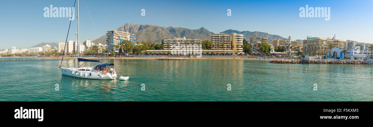 Eine Segelyacht verlässt den Hafen von Marina Marbella. Einen Panoramablick über diese schöne Marina an der Costa Del Sol, Spanien Stockfoto