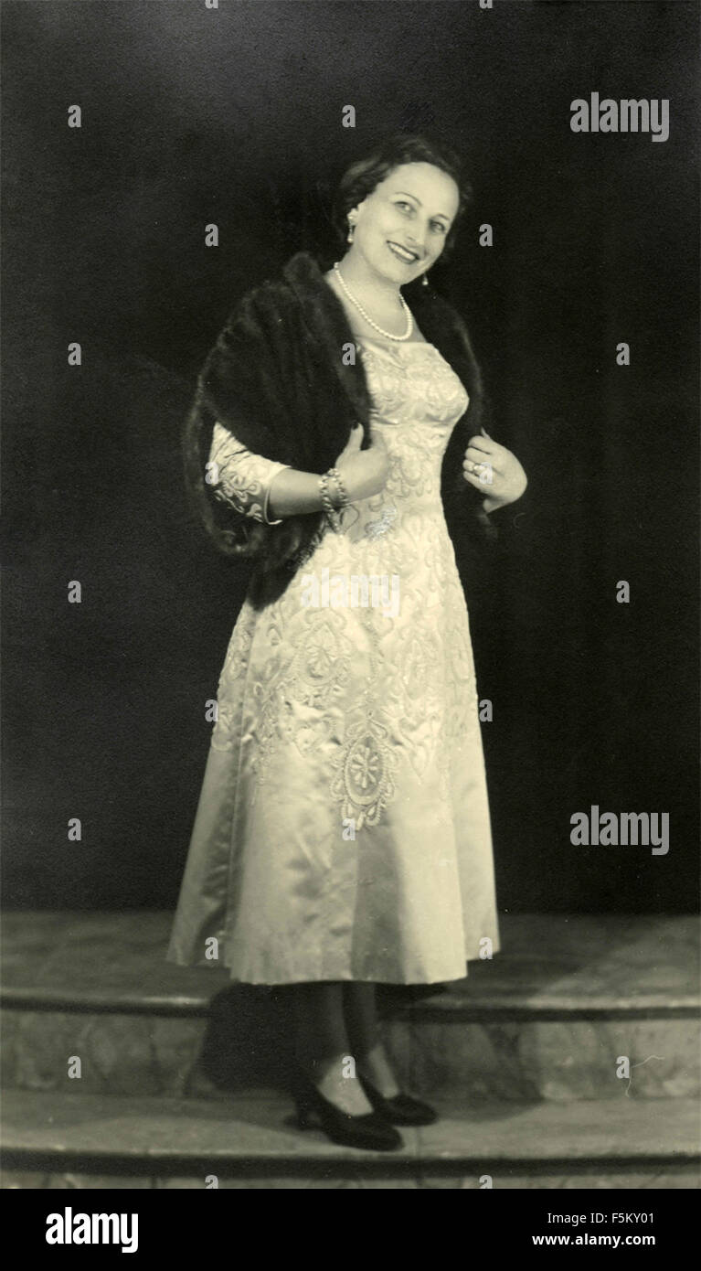 Eine Frau trägt ein weißes Kleid elegant der 50er Jahre mit Pelz Stola, Italien Stockfoto