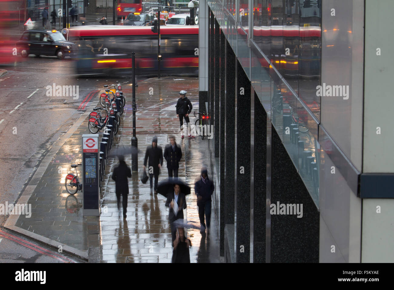 Niedrigen Verschlusszeit Menschen mit Regenschirmen verschwommen während Regen Gewitter in Wermut Street und Bishopsgate London während der morgendlichen Hauptverkehrszeit Stockfoto