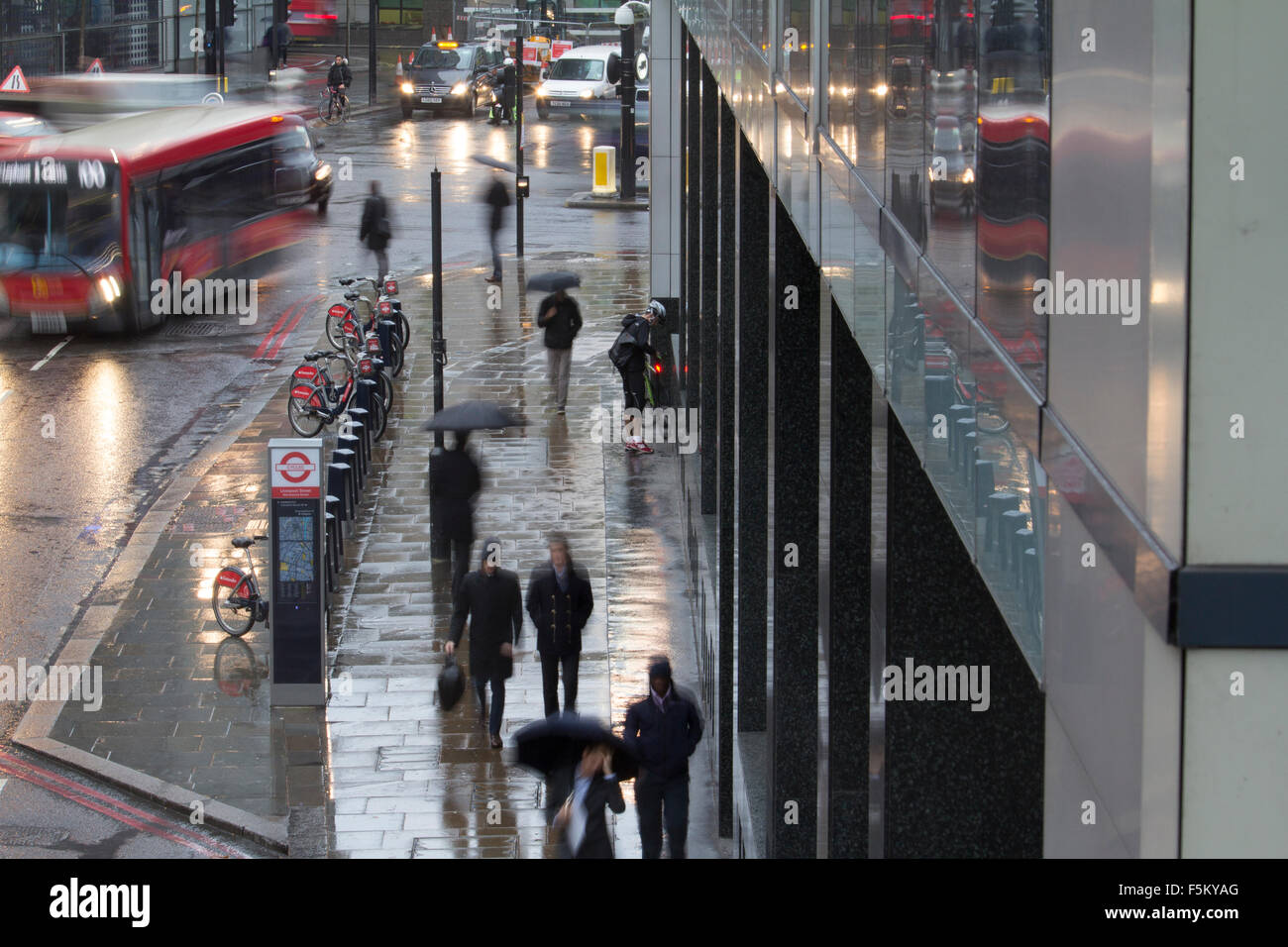 Niedrigen Verschlusszeit Menschen mit Regenschirmen verschwommen während Regen Gewitter in Wermut Street und Bishopsgate London während der morgendlichen Hauptverkehrszeit Stockfoto