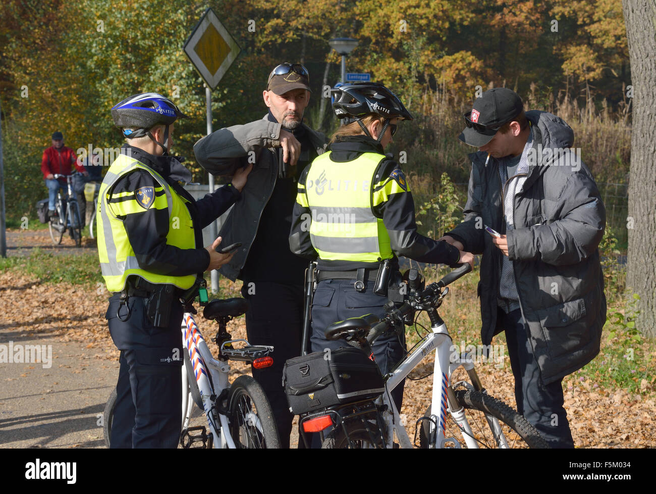 Polizei Frauen sind Menschen für ID und Waffen vor einer Demonstration gegen Migranten überprüfen. Stockfoto