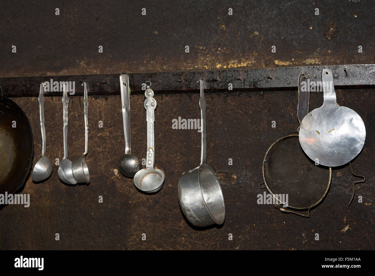 Indien, Himachal Pradesh, Spiti Valley, Schlüssel Klosterküche, glänzende Metall-Utensilien an Rauch geschwärzte Wand hängen Stockfoto