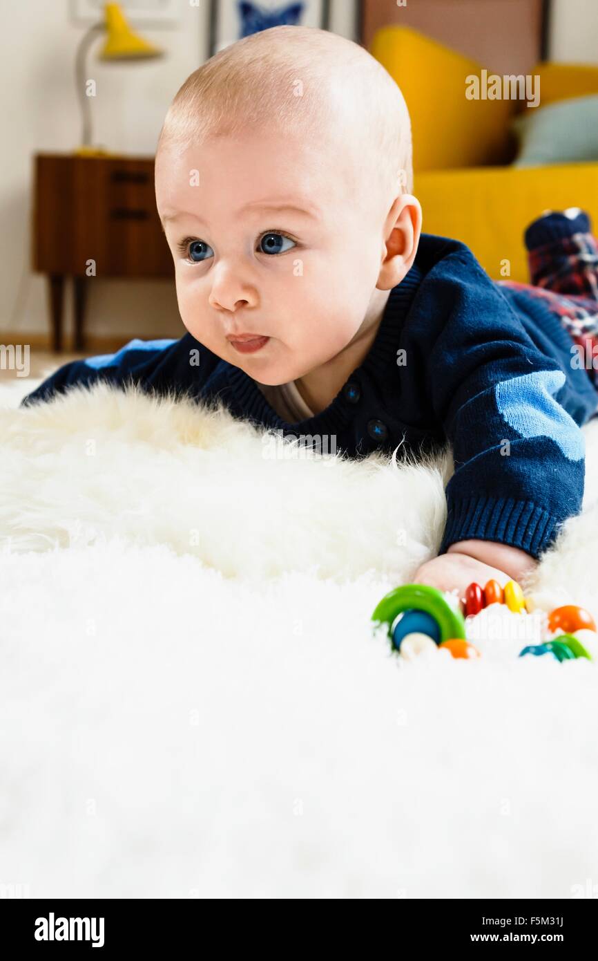 Baby Junge kriecht auf einem Teppich Stockfoto