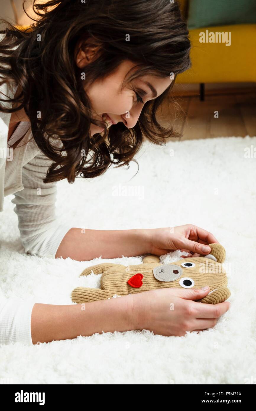 Frau Blick auf Babys Kuscheltier Stockfoto