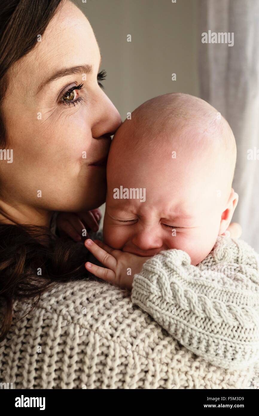 Beruhigende schreiendes Baby junge Mutter Stockfoto