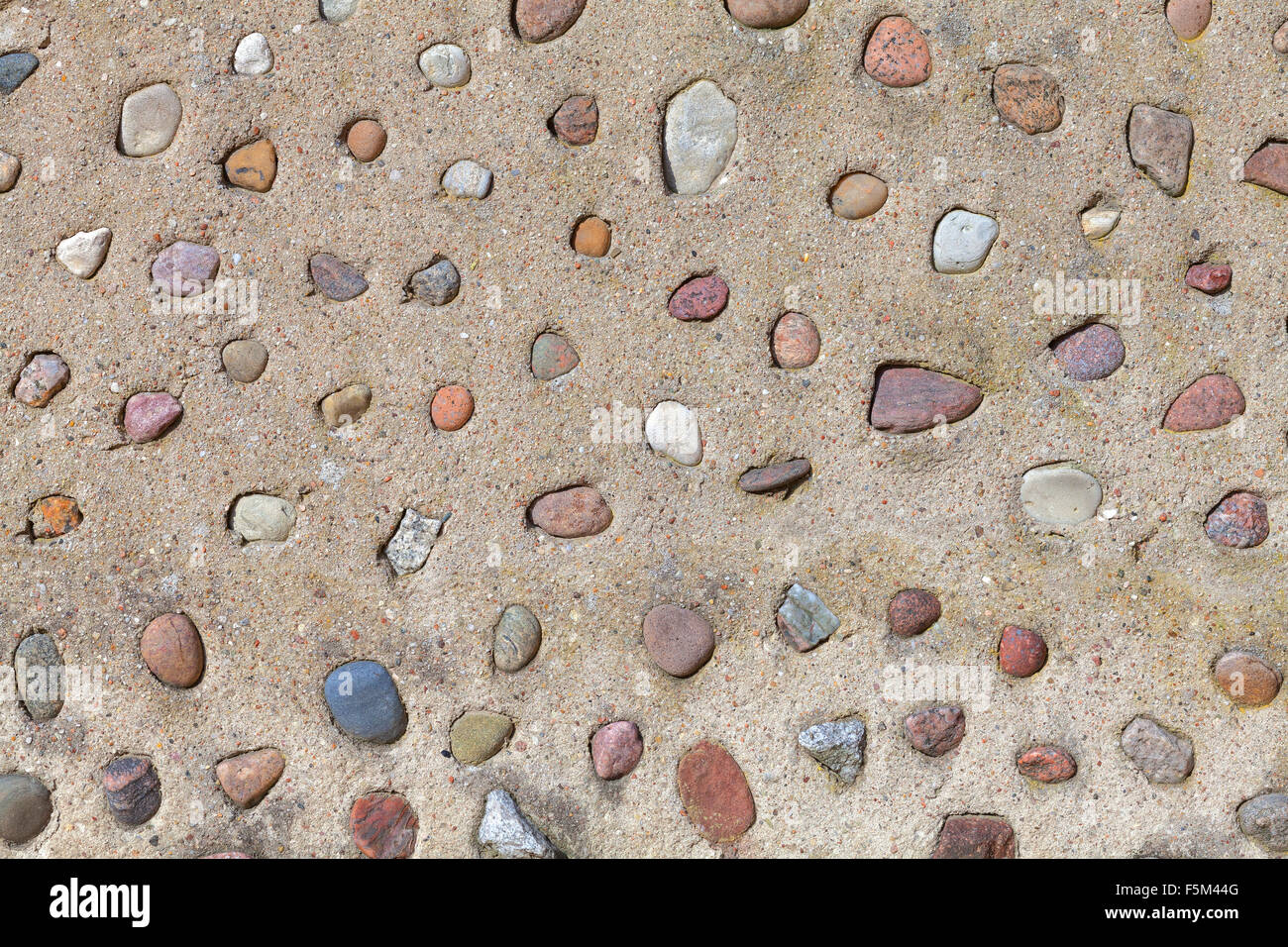 Echten Steinen in Betonmauer, natürliche abstrakten Hintergrund oder Textur. Stockfoto