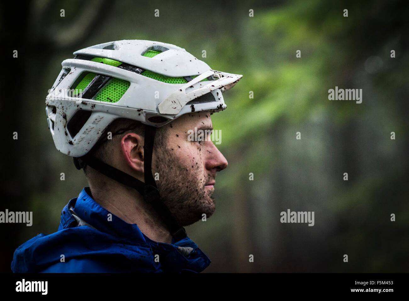 Profilbildnis von männlichen Mountainbiker mit Schlamm bespritzt Stockfoto