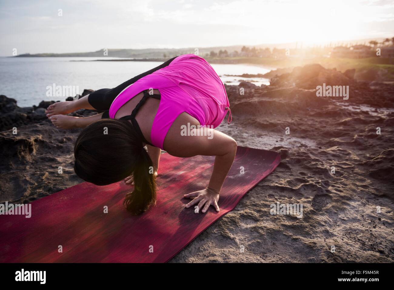 Frau am Küste praktizieren Yoga balancieren auf Hände, Hawea Punkt, Maui, Hawaii, USA Stockfoto