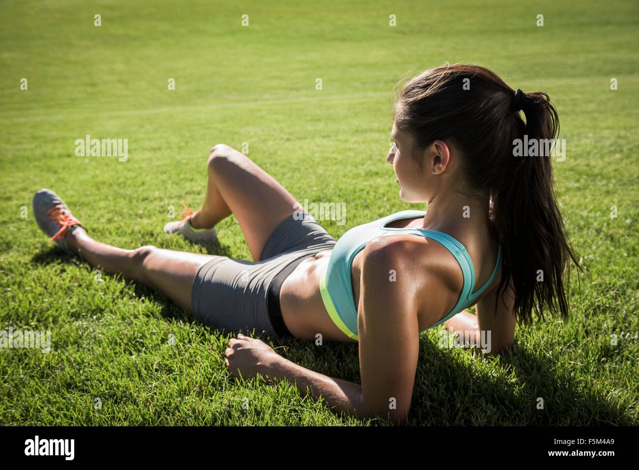 Junge Frau im sonnigen Park eine Trainings-Pause Stockfoto