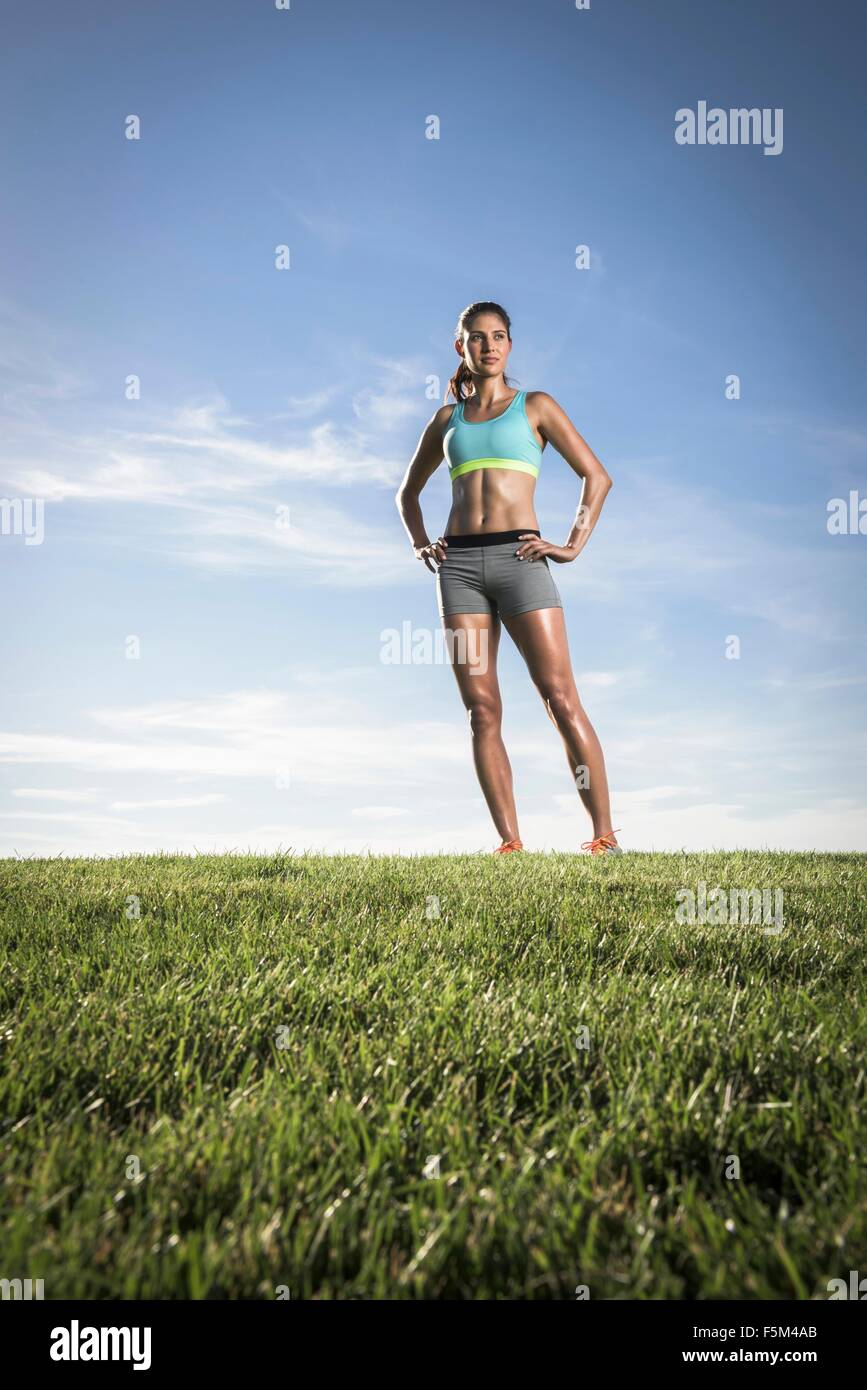 Porträt der selbstbewusste sportliche junge Frau mit Händen auf den Hüften im park Stockfoto