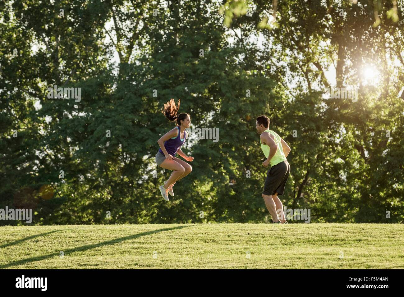 Junger Mann und Frau dabei springen Training im park Stockfoto