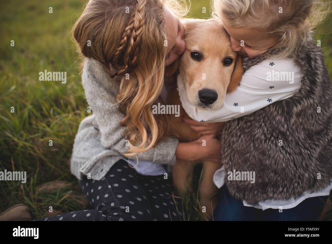 Zwei junge Mädchen umarmt Haustier-Hund, im freien Stockfoto