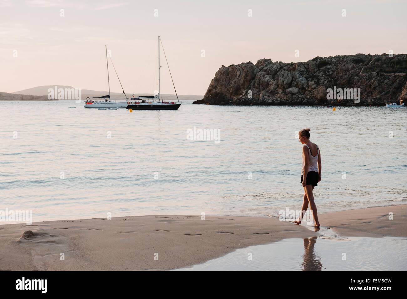 Mitte Erwachsene Frau spazieren am Strand, Menorca, Balearen, Spanien Stockfoto