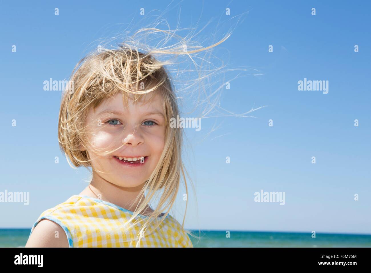 Porträt von Mädchen mit blonden Überseerennen Haar am Strand Stockfoto