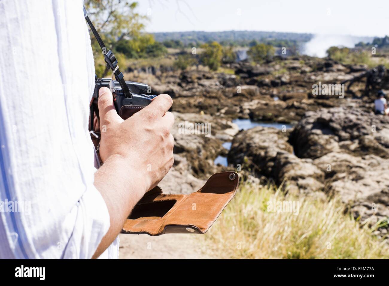 Schuss der Mann mit der Kamera in der Nähe von Victoria Falls, Sambia beschnitten Stockfoto