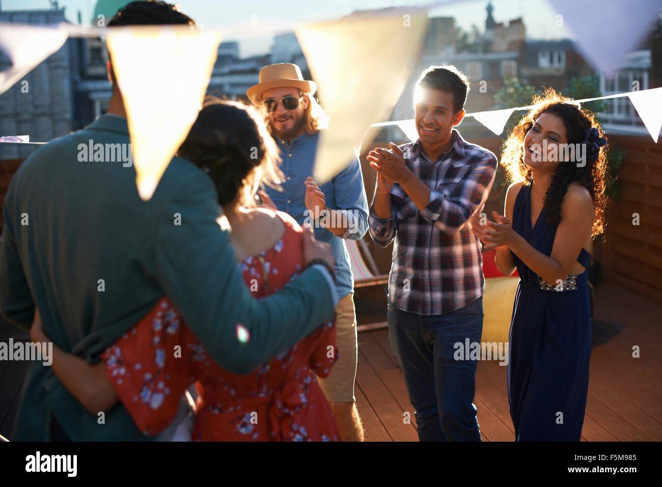 Freunde gratulieren zu zweit am frühen Abend Verlobungsfeier Stockfoto