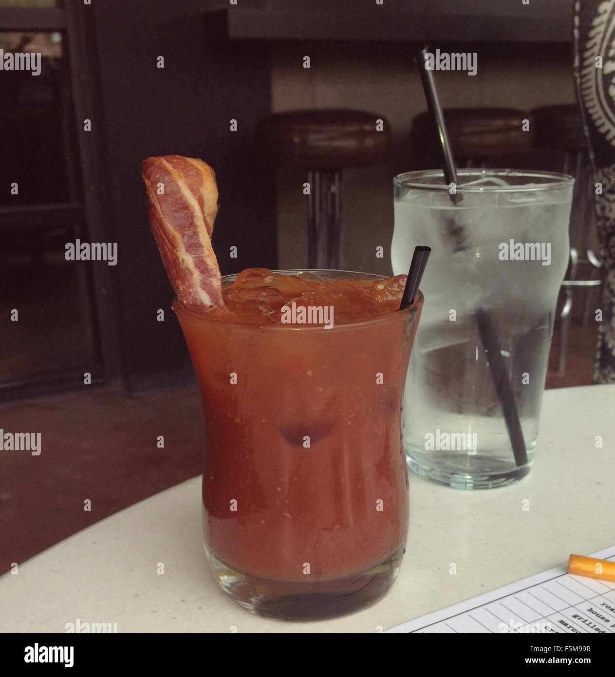 Leckere würzige Bloody Mary mit einem Streifen Speck für Kreativität und Extraaroma hinzugefügt Stockfoto