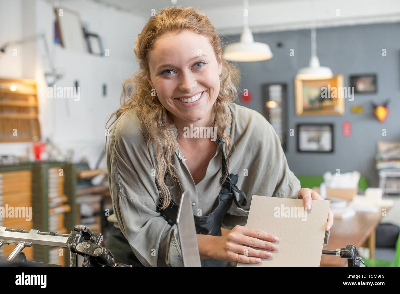 Druckerin Einfügen von Papier zu Druckmaschine in Werkstatt Stockfoto