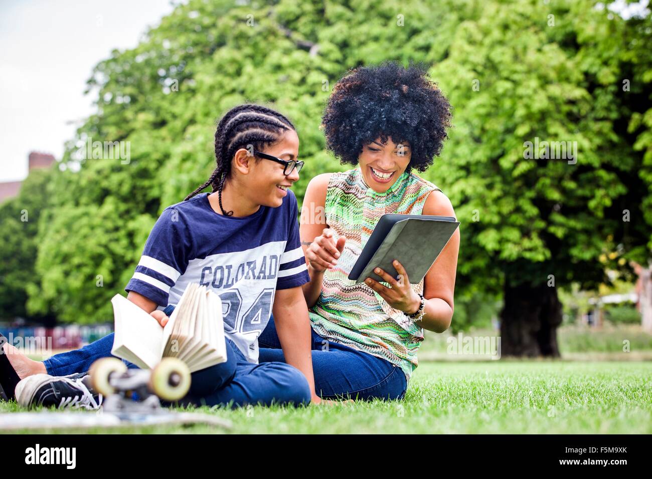 Junge und Mutter lesen digital-Tablette im park Stockfoto