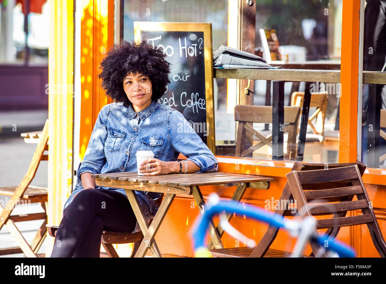 Reife Frau trinken Kaffee zum mitnehmen und Straßencafé Stockfoto