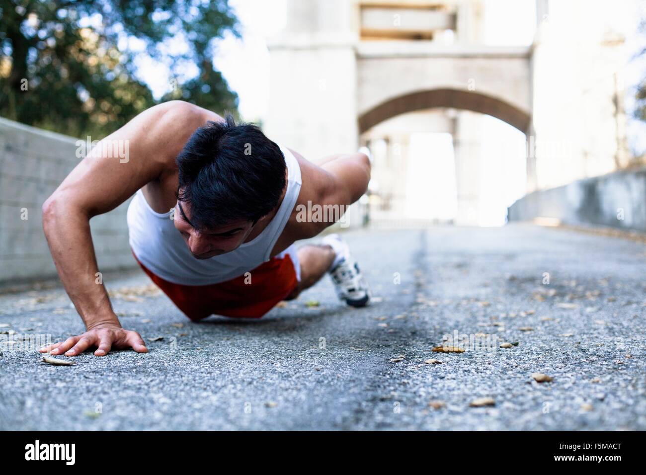 Mann tut Push Ups auf Brücke, Arroyo Seco Park, Pasadena, Kalifornien, USA Stockfoto