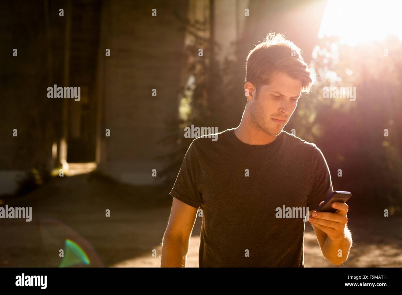 Jogger mit Telefon unter Bogenbrücke, Arroyo Seco Park, Pasadena, Kalifornien, USA Stockfoto