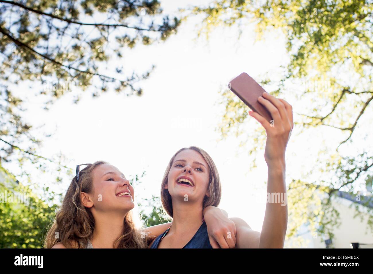 Zwei Mädchen im Teenageralter im Park unter Smartphone selfie Stockfoto