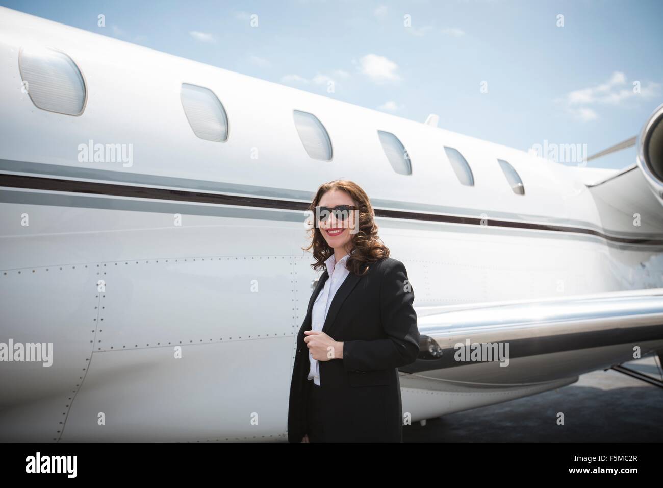 Porträt des weiblichen Geschäftsfrau und privat-Jet am Flughafen Stockfoto