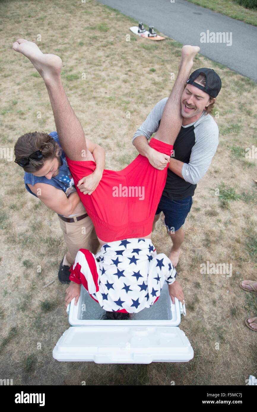 Zwei junge Männer Dunks Freund in Kühler am Independence Day, USA Stockfoto