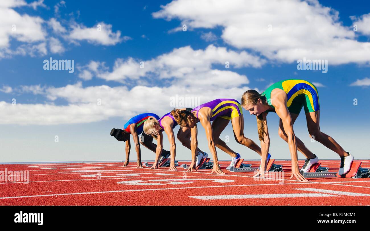 Vier weibliche Athleten in Startlöchern, kurz vor dem start Rennen Stockfoto