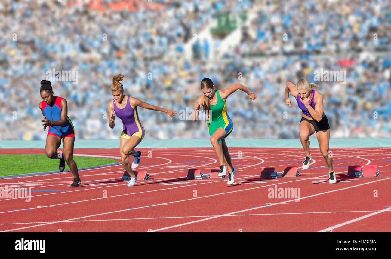 Vier weibliche Athleten auf Leichtathletik-Laufbahn verlassen Startblöcke Stockfoto