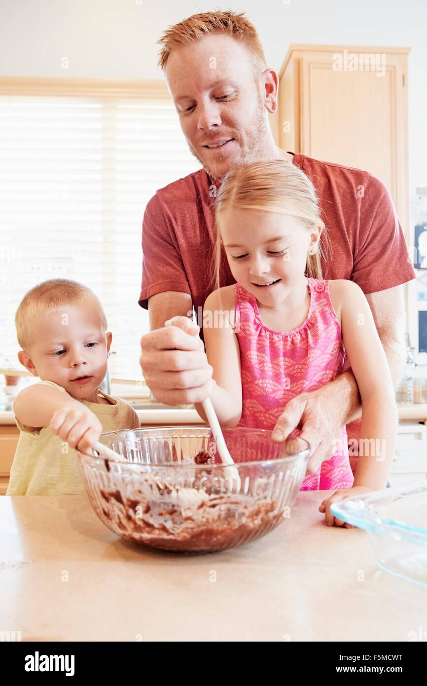 Familie Schmelzen der Schokolade in eine Rührschüssel geben Stockfoto