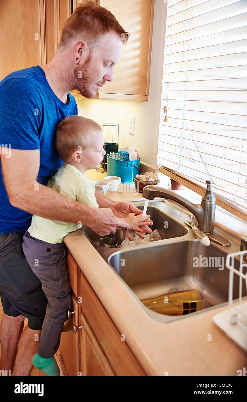 Vater Sohn Händewaschen im Spülbecken Stockfoto