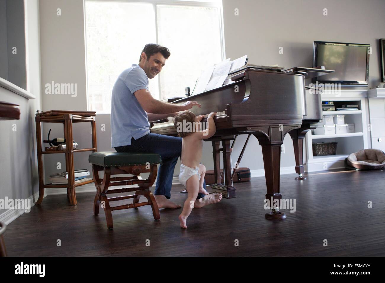 Vater und Baby junge am Klavier spielen Stockfoto