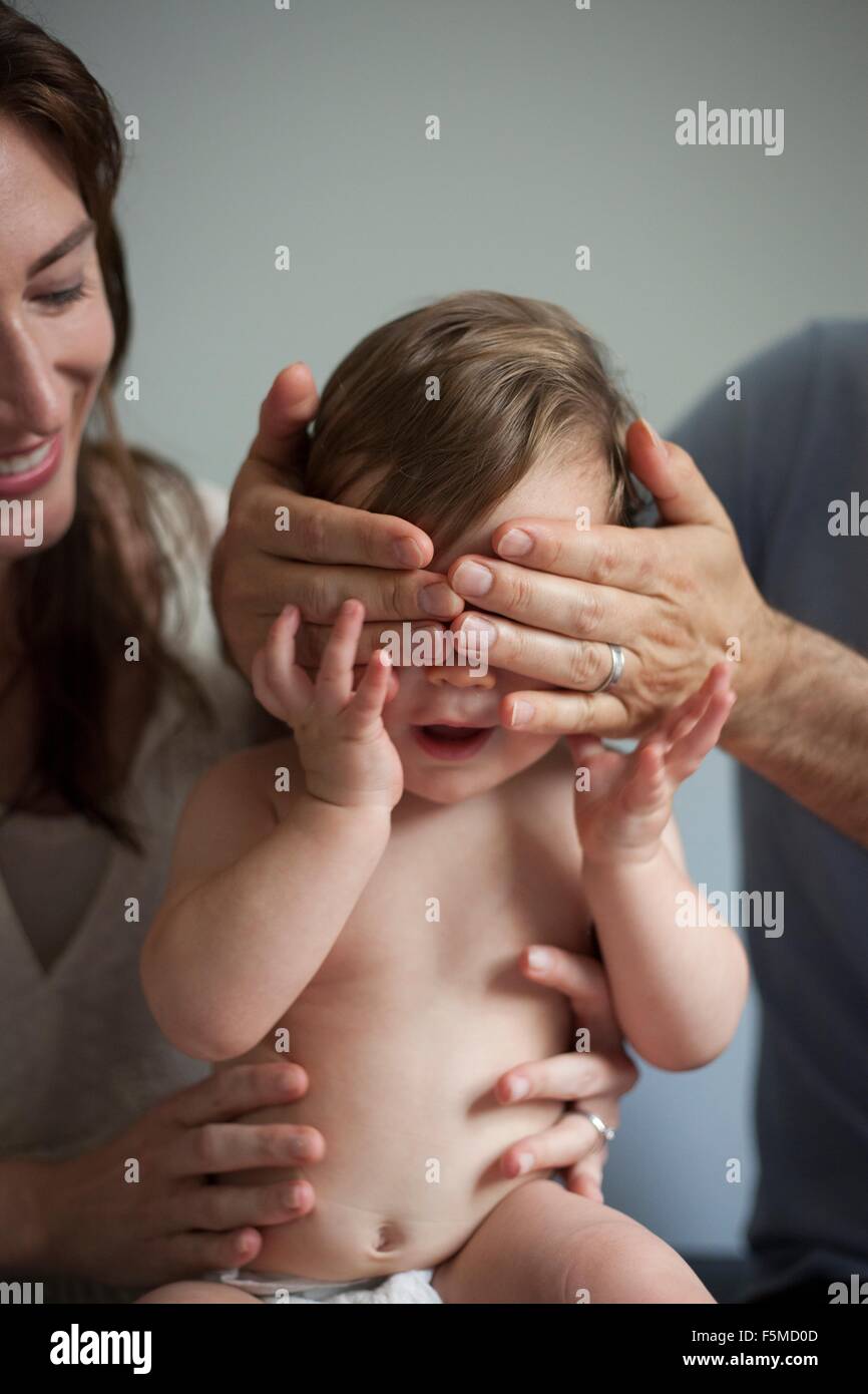 Mutter und Vater spielen Peek ein Boo mit Baby Stockfoto