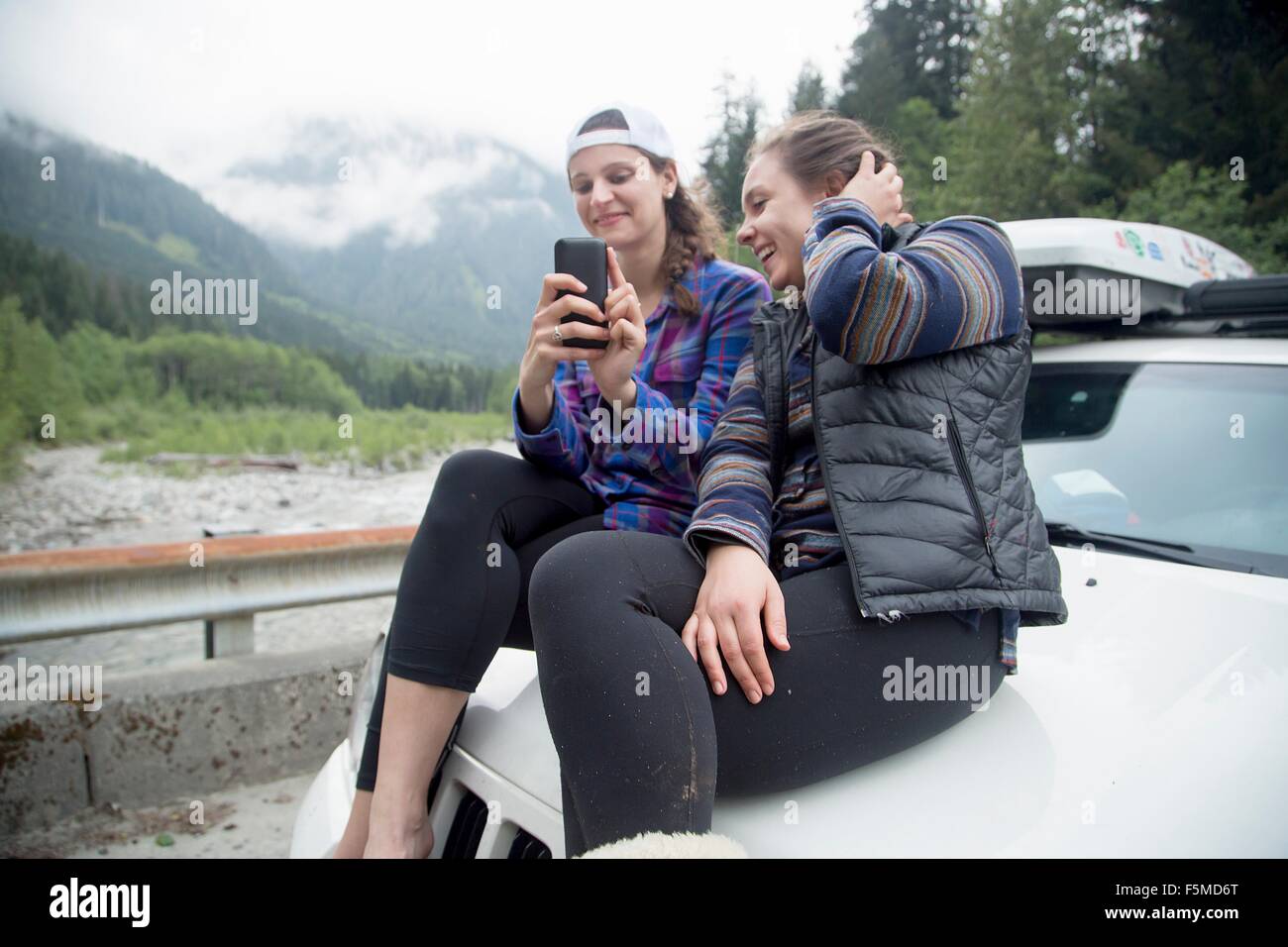 Wanderer mit Smartphone auf Motorhaube des Fahrzeugs, See Blanco, Washington, USA Stockfoto Wanderer mit Smartphone auf Motorhaube des Fahrzeugs, See Blanco, Washington, USA Stockfoto